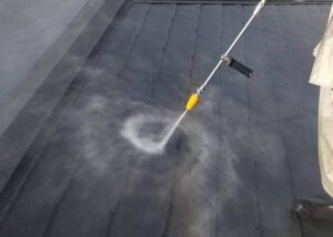 スレート瓦の屋根を高圧洗浄している様子です。